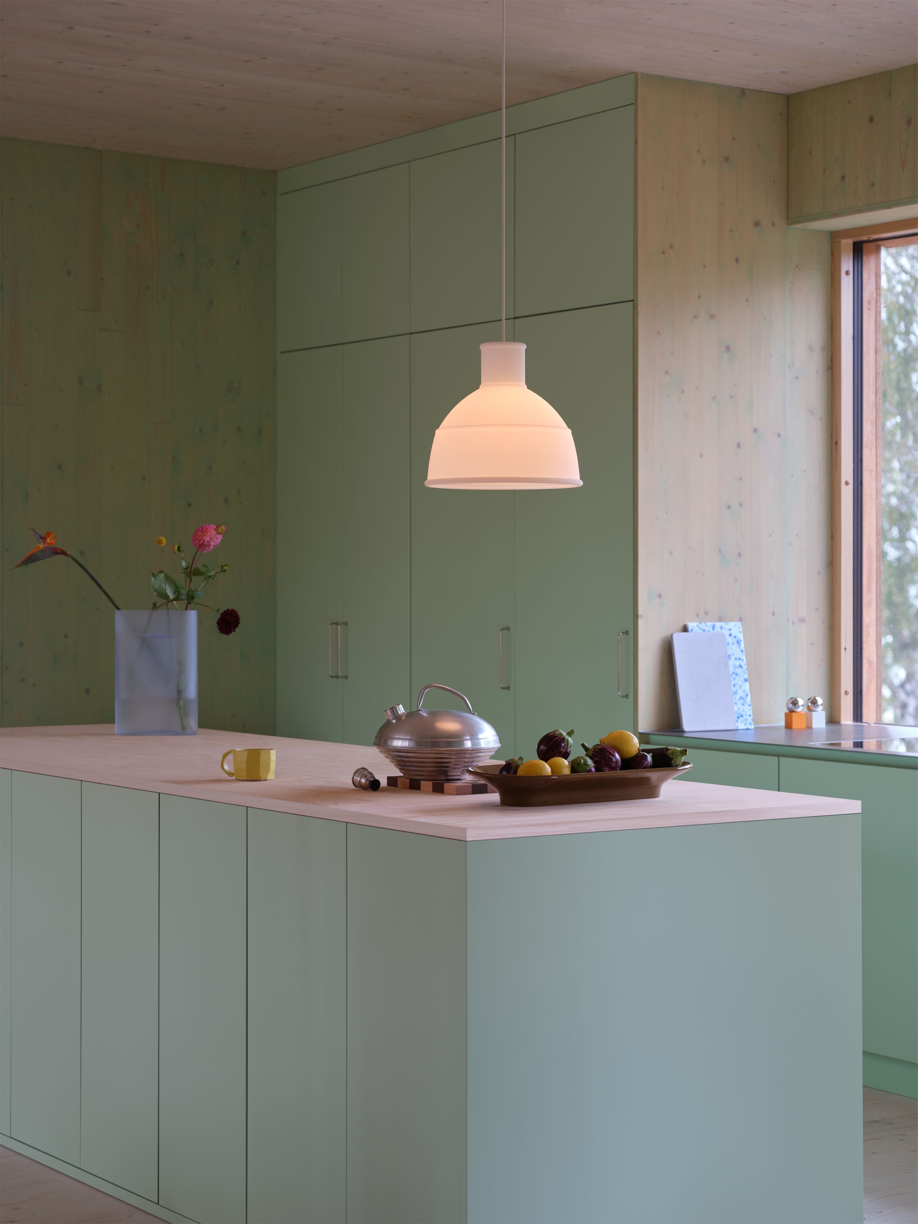 Küche mit salbeigrünen Fronten und Holzdecke.