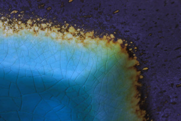 Makroaufnahme einer blauen Keramik-Oberfläche mit künstlerischer Craquelé-Struktur und goldenem Rand