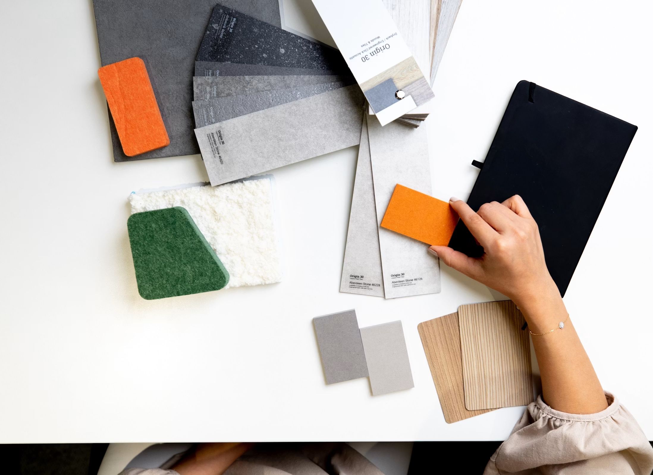 Materialmuster und Bodenproben für das Farbkonzept einer Stilberatung – Flatlay von oben.